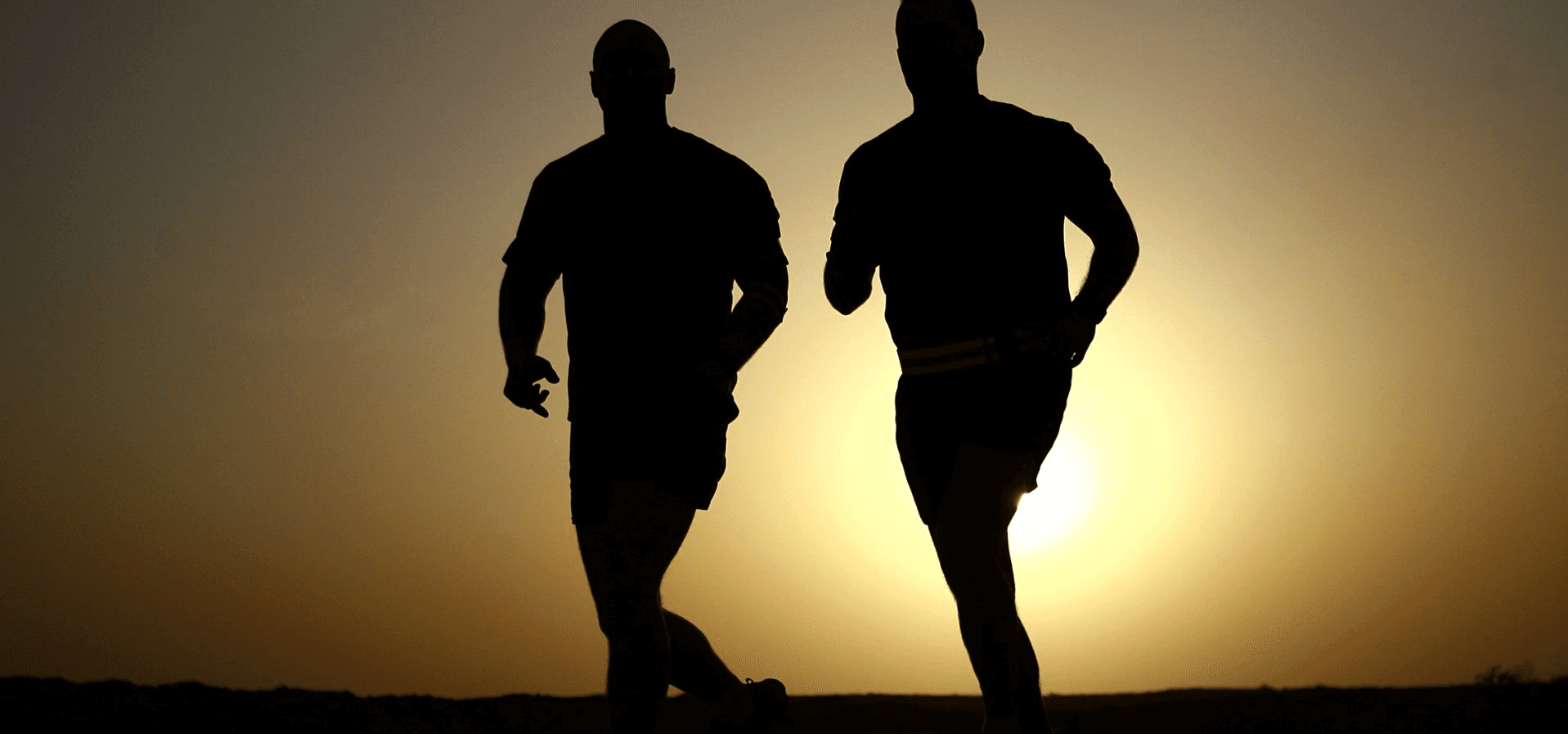 Two men running at sunrise or sunset